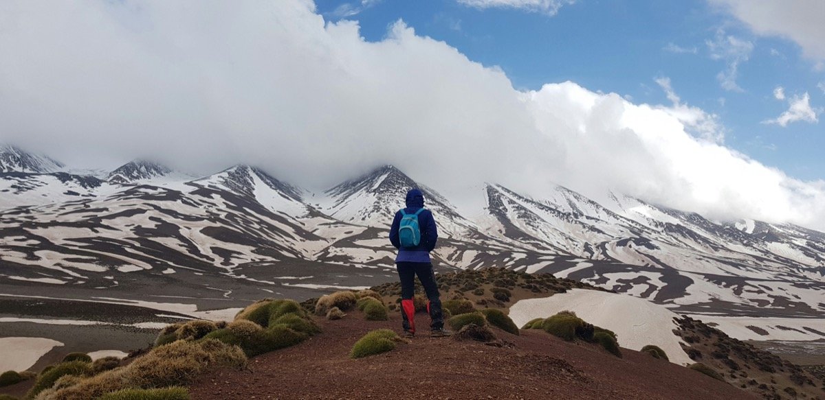 Hiker looking at snow-capped Atlas Mountains, Morocco