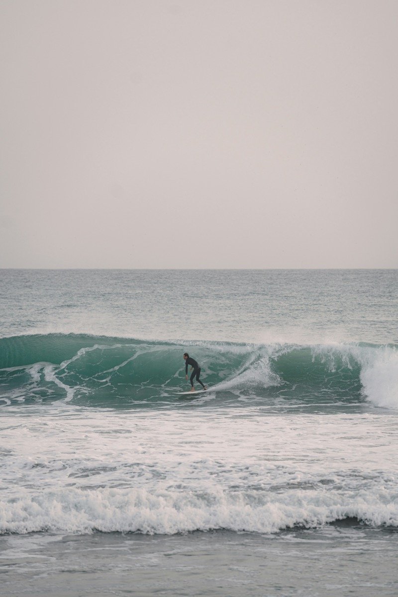 Surfers riding waves at Taghazout on the Atlantic coast of Morocco