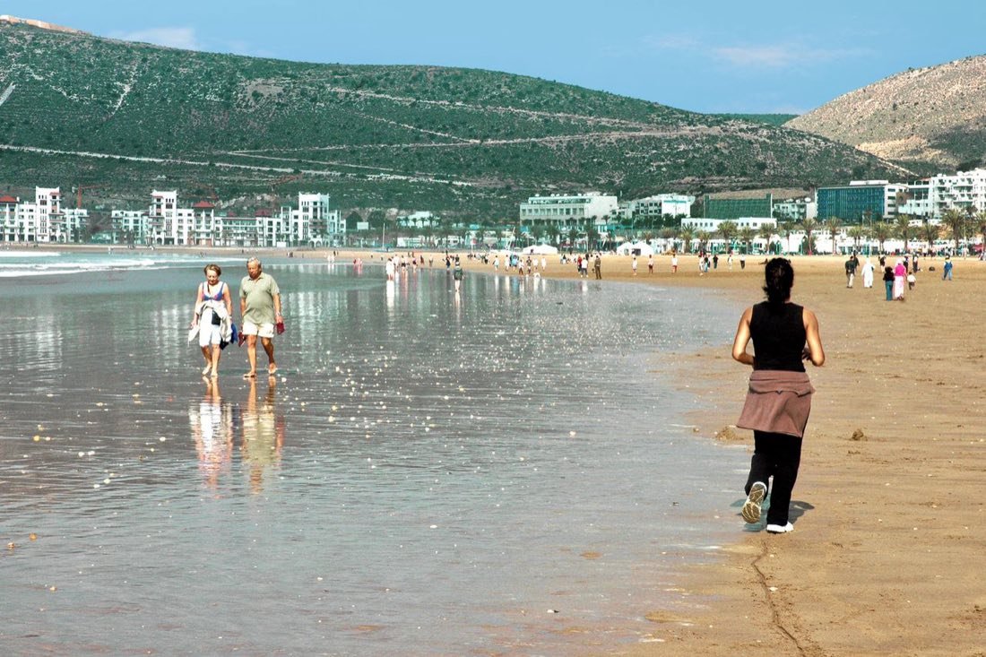 La amplia playa de Agadir con marea baja y la colina al fondo