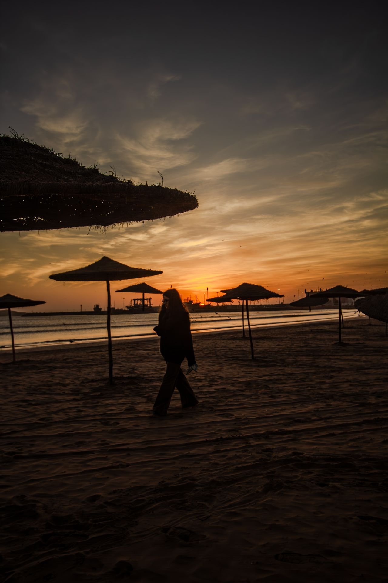 Paseo al atardecer entre las sombrillas de la playa