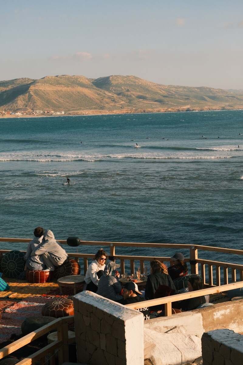 Visitors on a seaside cafe terrace overlooking the Atlantic and the headland
