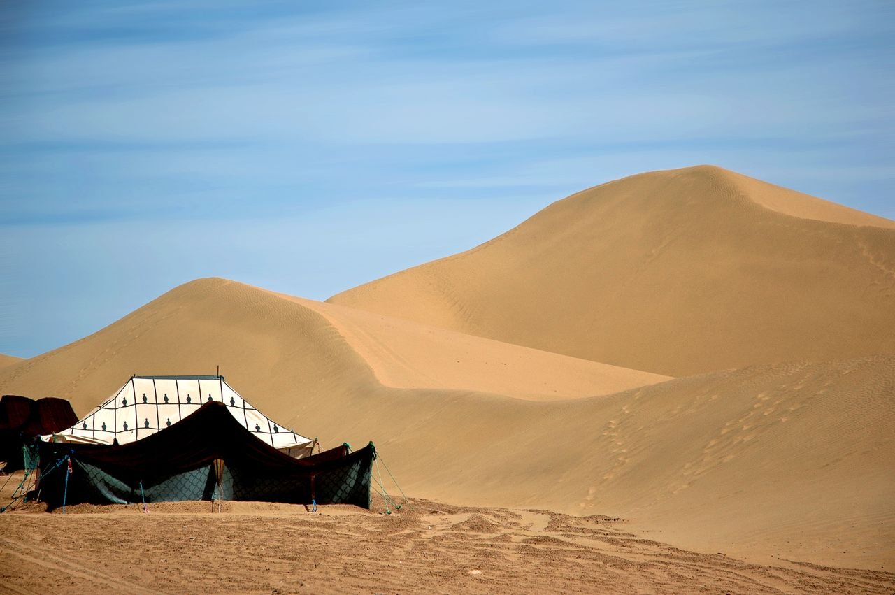 Tente berbère au pied d'une grande dune du Sahara marocain