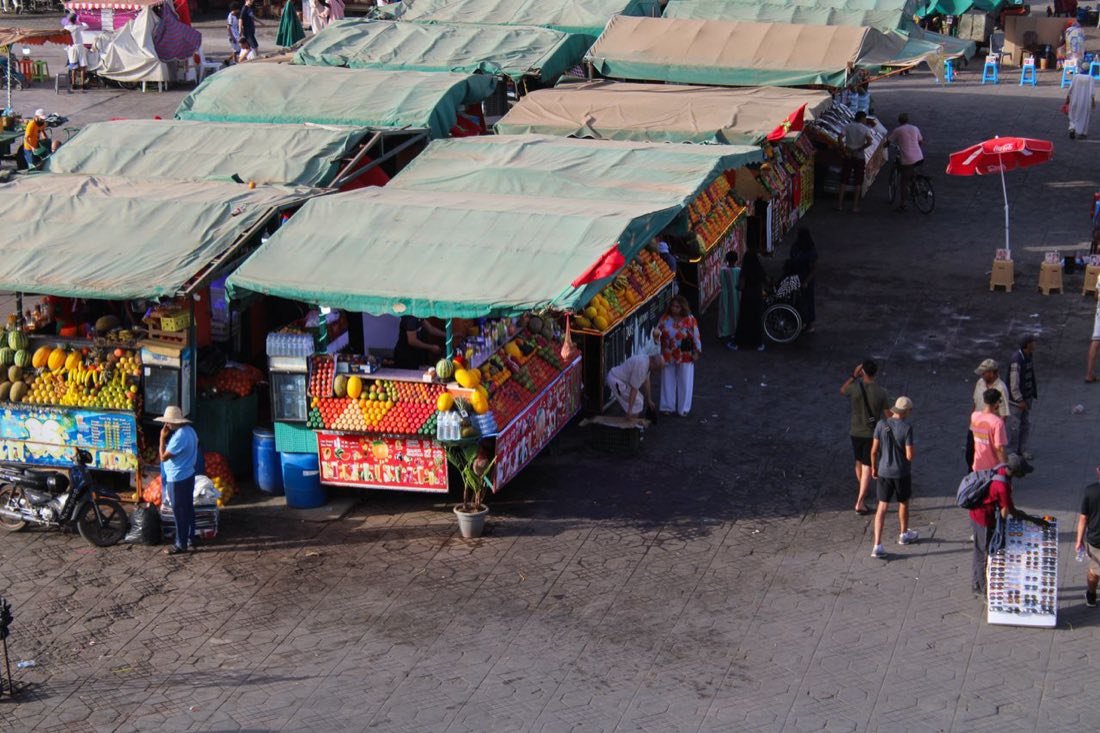 Fruit and vegetable stalls under awnings in a Moroccan souk