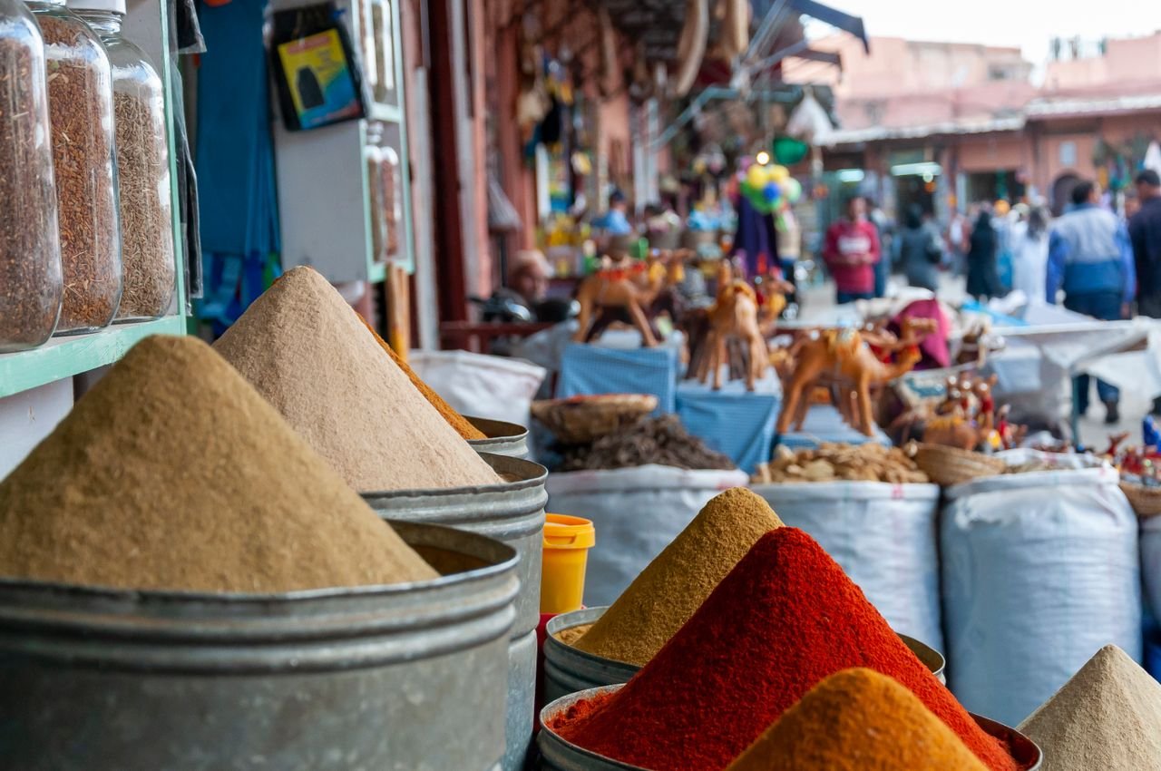 Cones of spices heaped in metal bins at the souk