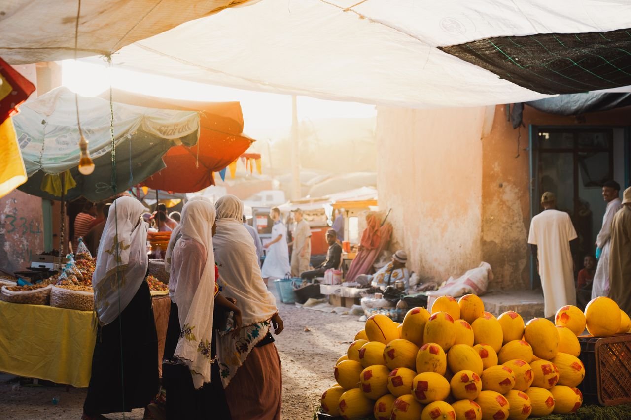 Mercado al aire libre en Tiznit, con fruta y vestimenta tradicional
