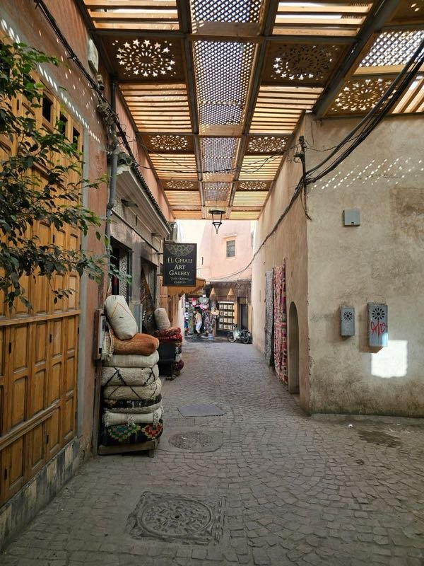 Callejón tranquilo de la medina de Marrakech con puertas de madera tallada