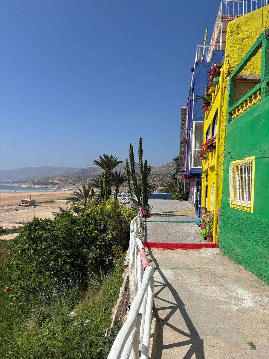 Casas de colores vivos junto a un sendero costero sobre la playa