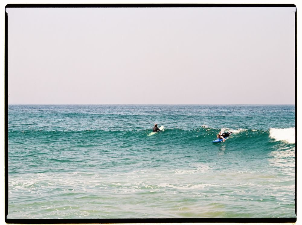 Two surfers sharing a wave in blue-green Atlantic water