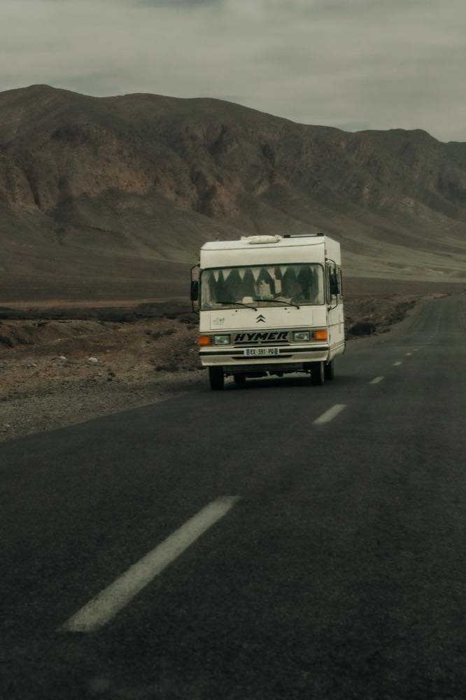 White camper van driving a mountain road in Morocco