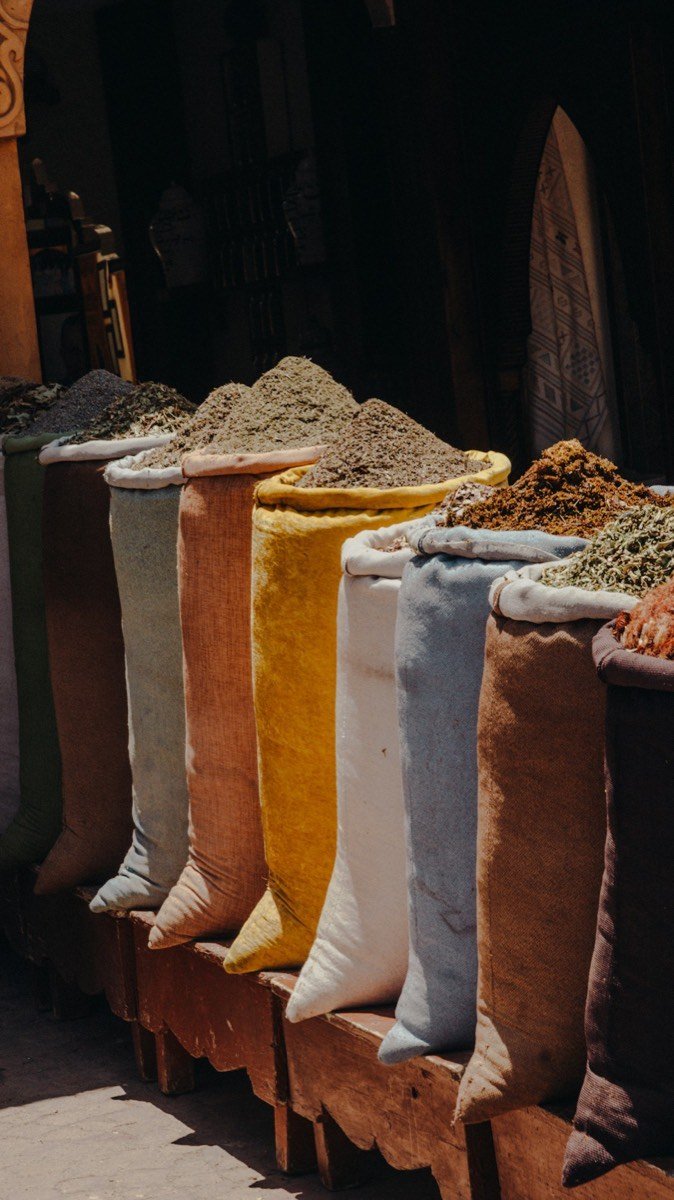 Sacs d'épices marocaines colorées dans un souk de Marrakech