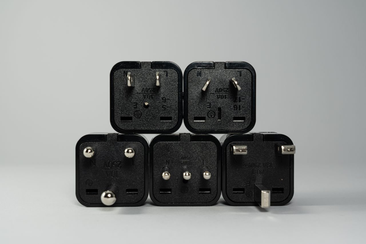 Stack of black travel plug adapters in different pin styles