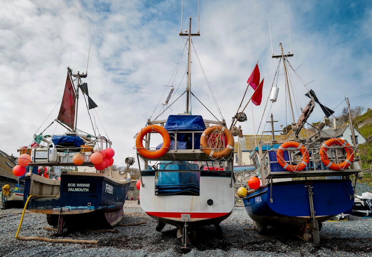 Rocky beach with fishing boats in Anza, Morocco