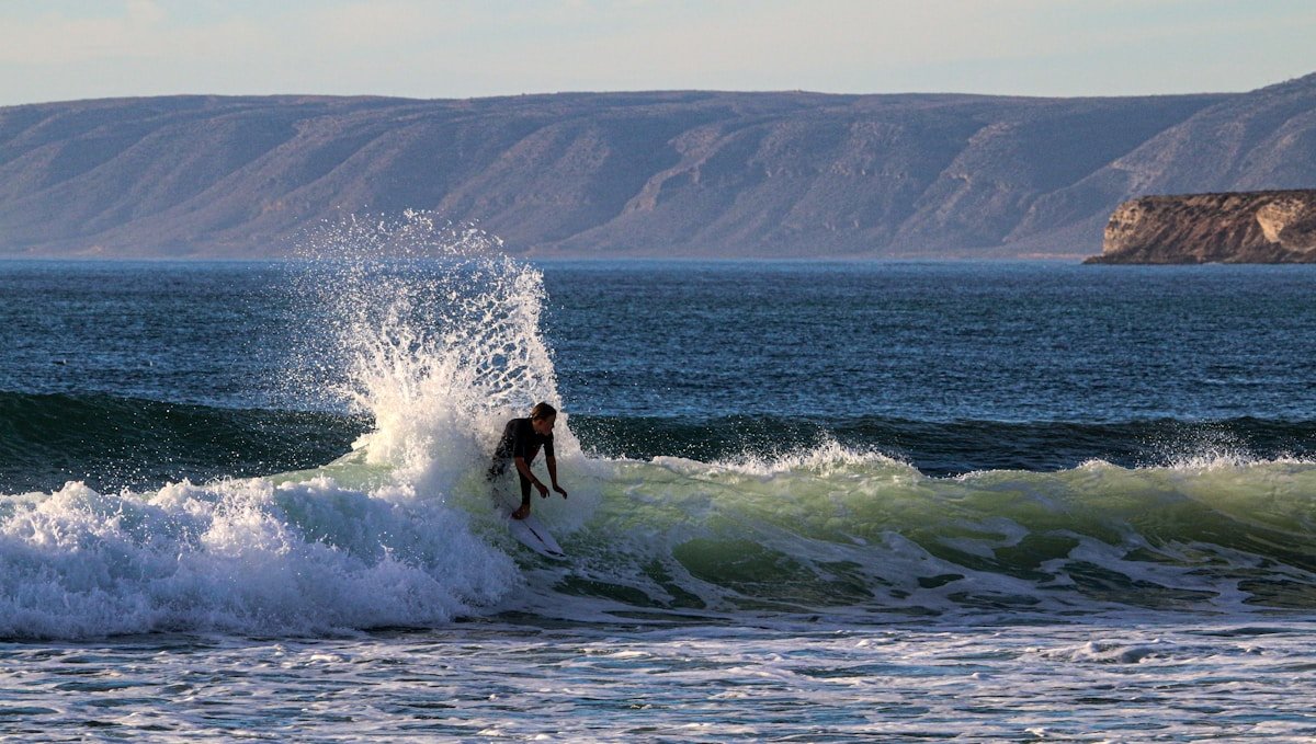 Surfer in wetsuit catching a wave in Morocco in January