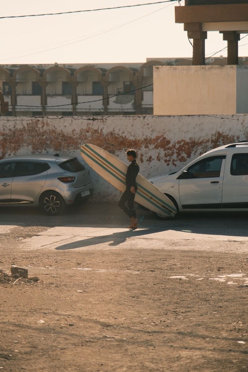 Surfer walking with board on the Moroccan coast
