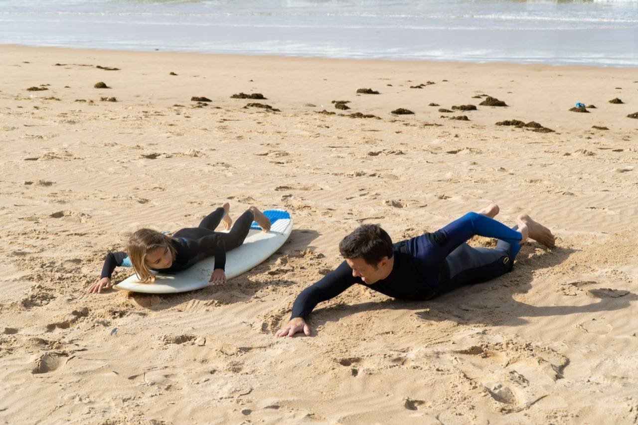 Surf instructor coaching a beginner at Taghazout beach, Morocco