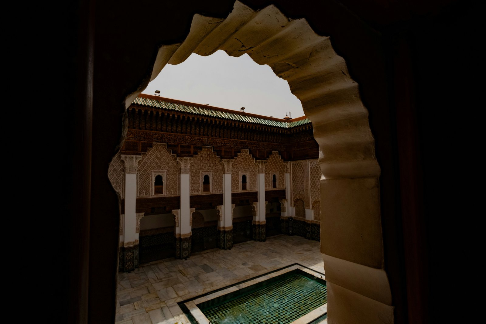 Ornate Moroccan riad courtyard with arched architecture and reflecting pool